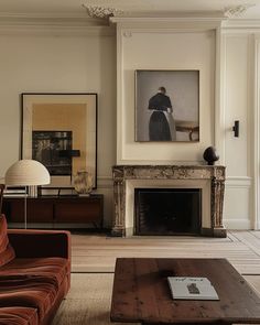 a living room filled with furniture and a fire place in front of a painting on the wall