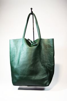 A lightweight and spacious Leather Shopping Bag-Green you can use for your office, gym and after-hours essentials while still looking stylish. Handmade from supple calfskin Italian leather, the versatile look features over-the-shoulder handles and minimal detailing. Raw edges and no lining makes this style super light and easy to fold when traveling. Inside is a zippered document pouch and a leather cell phone pouch. Details: Color: Green Two leather strap for closing the bag.Natural unlined int