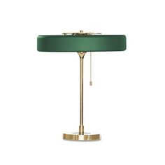 a green lamp on a white background with a gold base and chain hanging from it