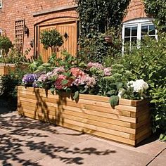 a wooden planter filled with lots of flowers