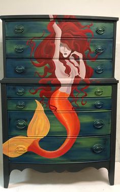 a painted dresser with an image of a mermaid on it