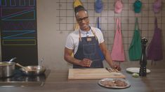 a man standing in front of a cutting board with food on it