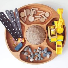 a wooden tray filled with rocks and toys