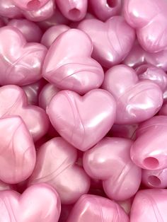 pink heart shaped balloons are piled together