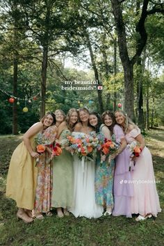 a group of women standing next to each other in front of some trees and grass