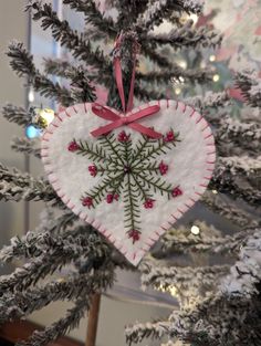 a heart shaped ornament hanging from a christmas tree