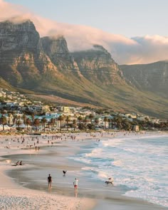 people on the beach with mountains in the background