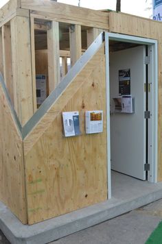 an outhouse is being built with wooden walls and siding on the outside, as well as construction materials