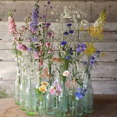 a group of vases filled with flowers on top of a wooden table