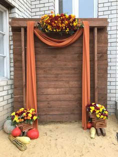 an outdoor area with flowers and vegetables on the ground near a wooden structure that is made out of wood planks