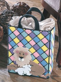 a small bag with a teddy bear on it sitting next to some yarn balls and scissors