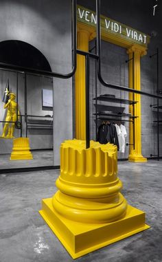 a yellow sculpture in the middle of a room filled with mannequins and other items