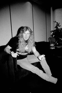 a black and white photo of a woman sitting on a couch