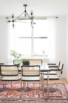 a dining room table with chairs and a rug