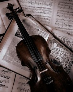 an old violin laying on top of music sheets