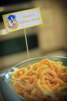 a glass bowl filled with pasta rings and a sign that says sonic's golden rings