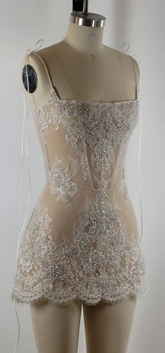 a mannequin with white lace on it's bust and back, in the shape of a dress