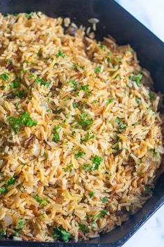 a pan filled with rice and vegetables on top of a table