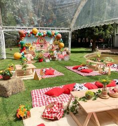 an outdoor party setup with red and white checkered tablecloths, hay bales, picnic tables and decorations