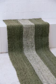 two green rugs sitting next to each other on the floor in front of a white wall