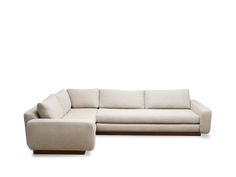 a white sectional couch sitting on top of a wooden table