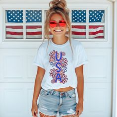 Introducing our U.S.A. t-shirt! This playful floral graphic is the perfect way to show off your patriotic side. Lightweight and breathable, this shirt will keep you comfy and stylish all day long. (USA! USA!) T-Shirt:    Comfort: Indulge in the luxurious softness and durability of 100% ring-spun cotton, providing a comfortable feel against the skin. Ideal for anyone looking for a premium unisex shirt. Pre-shrunk White T-shirt With American Flag Print For Spring, American Flag Print Graphic Tee For Spring, American Flag Print T-shirt For Spring, 4th Of July Casual T-shirt With Sublimation Print, Casual 4th Of July T-shirt With Sublimation Print, Patriotic White T-shirt For Spring, Patriotic American Flag T-shirt For Summer, Spring American Flag Print Relaxed T-shirt, Spring Relaxed Fit T-shirt With American Flag Print