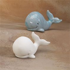 two ceramic whale figurines sitting next to each other