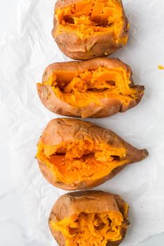 three sweet potatoes sitting on top of white paper