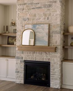 a stone fireplace with a mirror above it