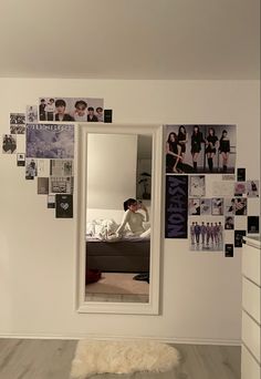 a bedroom with pictures on the wall and a mirror in the corner that has been decorated with black and white photos