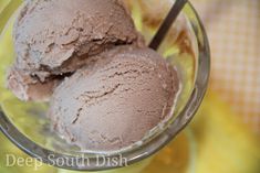 two scoops of chocolate ice cream in a glass bowl