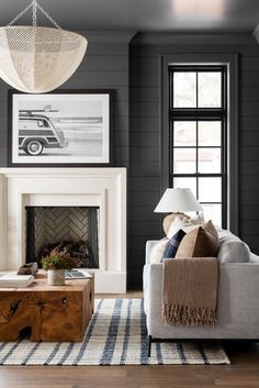 a living room filled with furniture and a fire place under a chandelier hanging from the ceiling