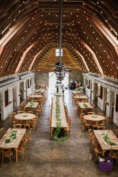 the inside of a barn with tables and chairs set up for an outdoor wedding reception