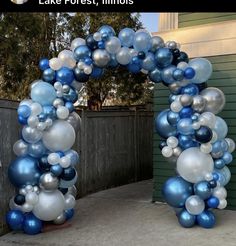 an arch made out of blue and white balloons