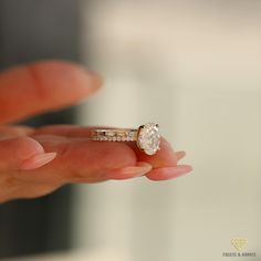 a person holding a ring with a diamond on it's finger in their hand