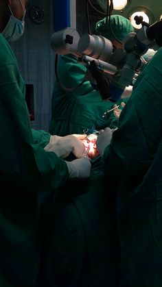 two surgeons performing surgery on a patient in an operating room with lights and medical equipment