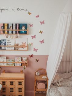 a child's bedroom decorated in pink and white with lots of butterflies on the wall