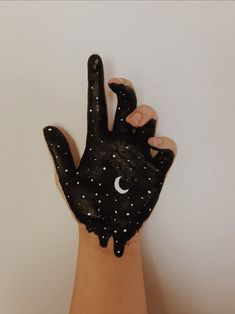 a person's hand is covered in black paint with stars and moon on it