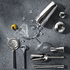 various kitchen utensils are arranged on the floor next to each other, including a cocktail shaker