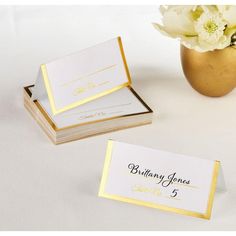 two place cards and a vase with flowers