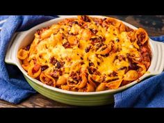 a casserole dish filled with pasta, meat and cheese on a blue towel