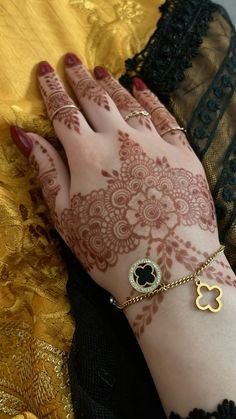 a woman's hand with henna tattoos and bracelets on her left arm