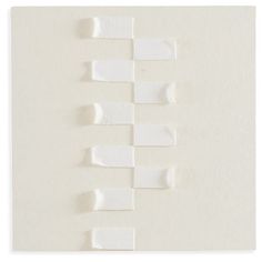 several pieces of white paper on top of each other with different sized strips attached to them