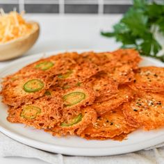 some food is on a white plate and next to a bowl with parmesan cheese