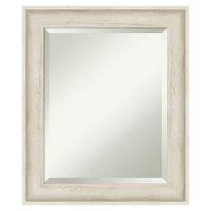 a white wooden frame mirror on a white wall with a light colored wood border around it