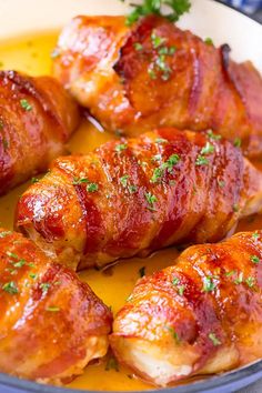 several pieces of bacon wrapped in sauce and garnished with parsley