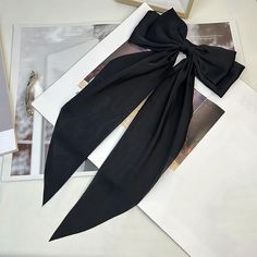 Black Satin Clip-In Oversized Hair Bow Make a statement with our Black Satin Clip-In Oversized Hair Bow, a chic addition to any hairstyle. This oversized bow, measuring 15" in length, is crafted from luxurious black satin for a chic and elegant look. Perfect for adding a touch of sophistication to your outfit, whether you're attending a special occasion or simply want to elevate your everyday style. The clip-in design ensures easy and secure attachment, making it effortless to achieve a polished Silk Hair Bow, Boring Hair, Secure Attachment, Dressy Pants, Chic And Elegant, Making Hair Bows, Silk Hair, Hair Accessories Jewelry, Stylish Hair