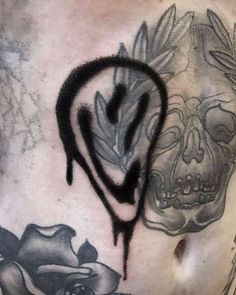 a man's chest with black ink on it and a skull in the middle