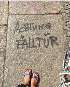 someone is standing on the sidewalk with their feet up in front of a sign that says acting failure