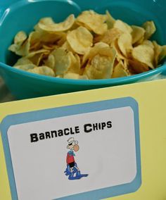 a blue bowl filled with corn chips next to a sign that says bannacle chips